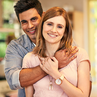 Buy stock photo Portrait of an affectionate young couple standing in their kitchen