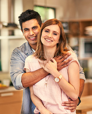 Buy stock photo Portrait of an affectionate young couple standing in their kitchen