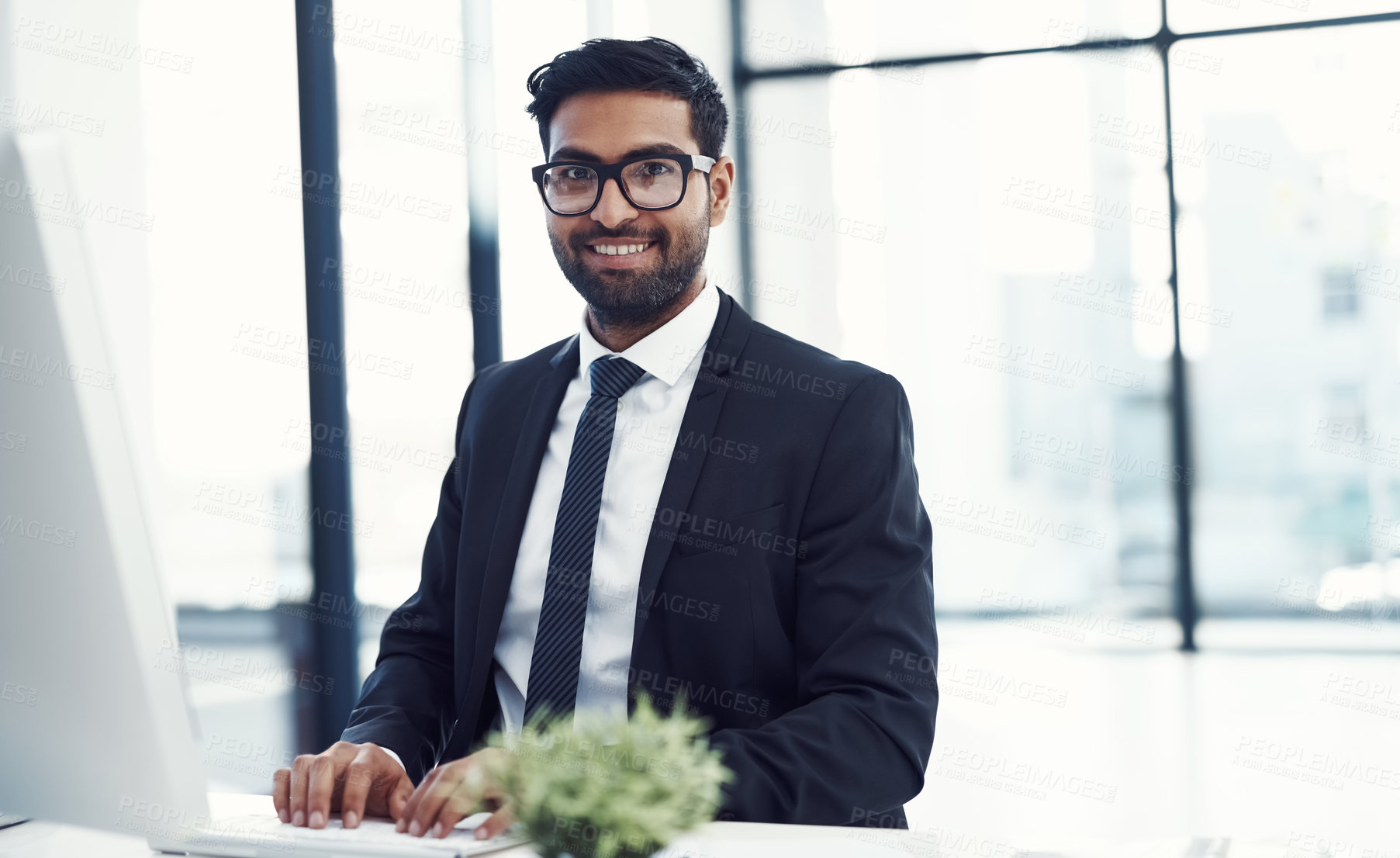 Buy stock photo Cropped shot of a young businessman working on his computer