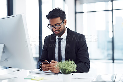 Buy stock photo Cropped shot of a young businessman using his cellphone at his desk