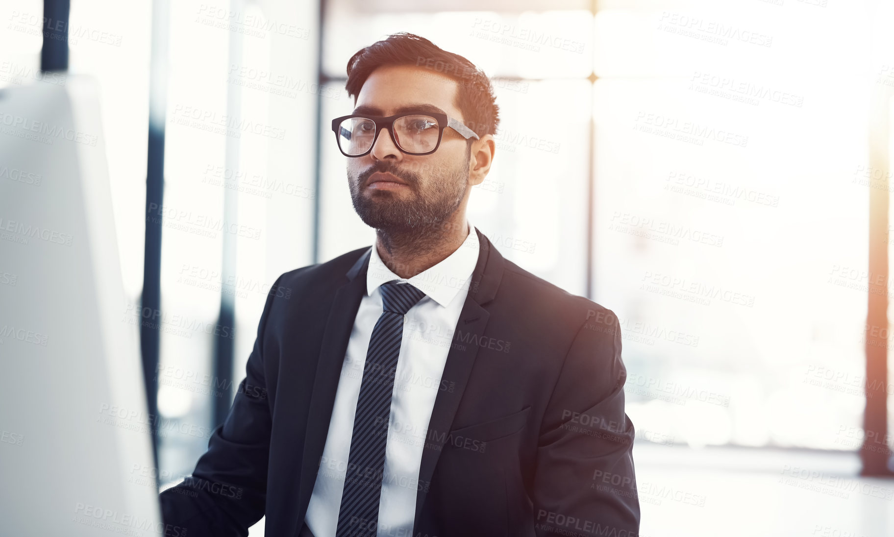 Buy stock photo Cropped shot of a young businessman working on his computer