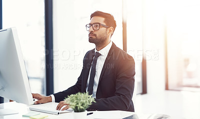 Buy stock photo Cropped shot of a young businessman working on his computer