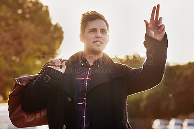 Buy stock photo Shot of a handsome young man hailing a cab