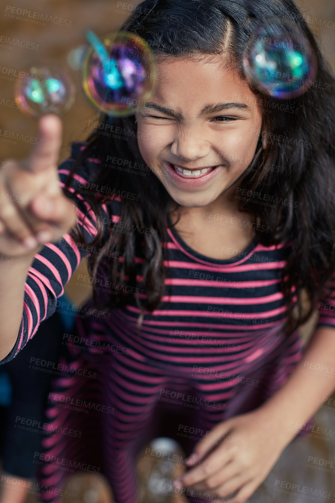 Buy stock photo Shot of a little girl playing with bubbles inside her home