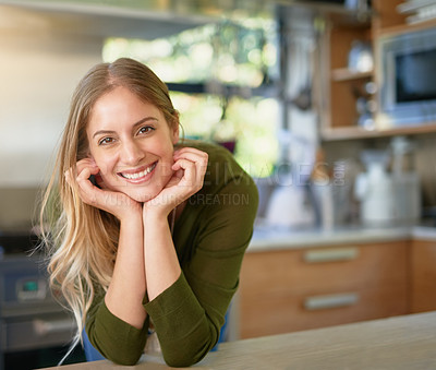 Buy stock photo Portrait of a smiling young woman leaning on her kitchen counter at home