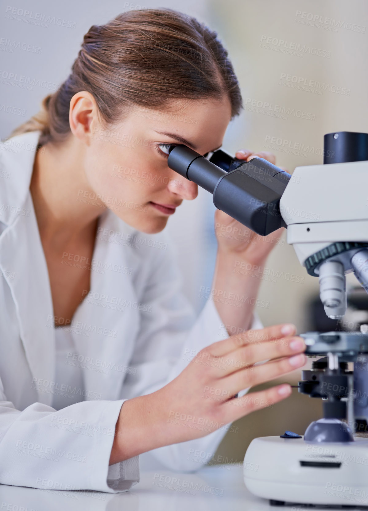 Buy stock photo Shot of a scientist using a microscope while sitting in a laboratory