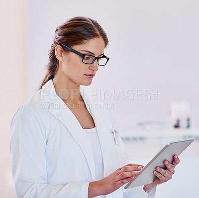 Buy stock photo Shot of a scientist using a digital tablet while standing in a laboratory