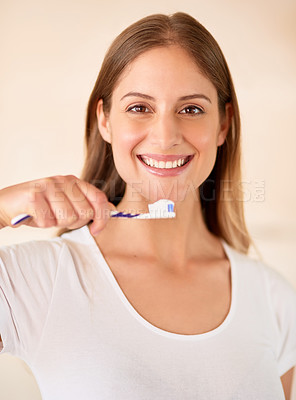 Buy stock photo Portrait of a young woman brushing her teeth at home