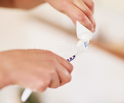 Buy stock photo Closeup shot of an unrecognisable woman squeezing toothpaste onto her toothbrush