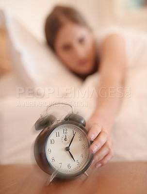 Buy stock photo Cropped shot of a young woman waking up and reaching for her alarm clock at home