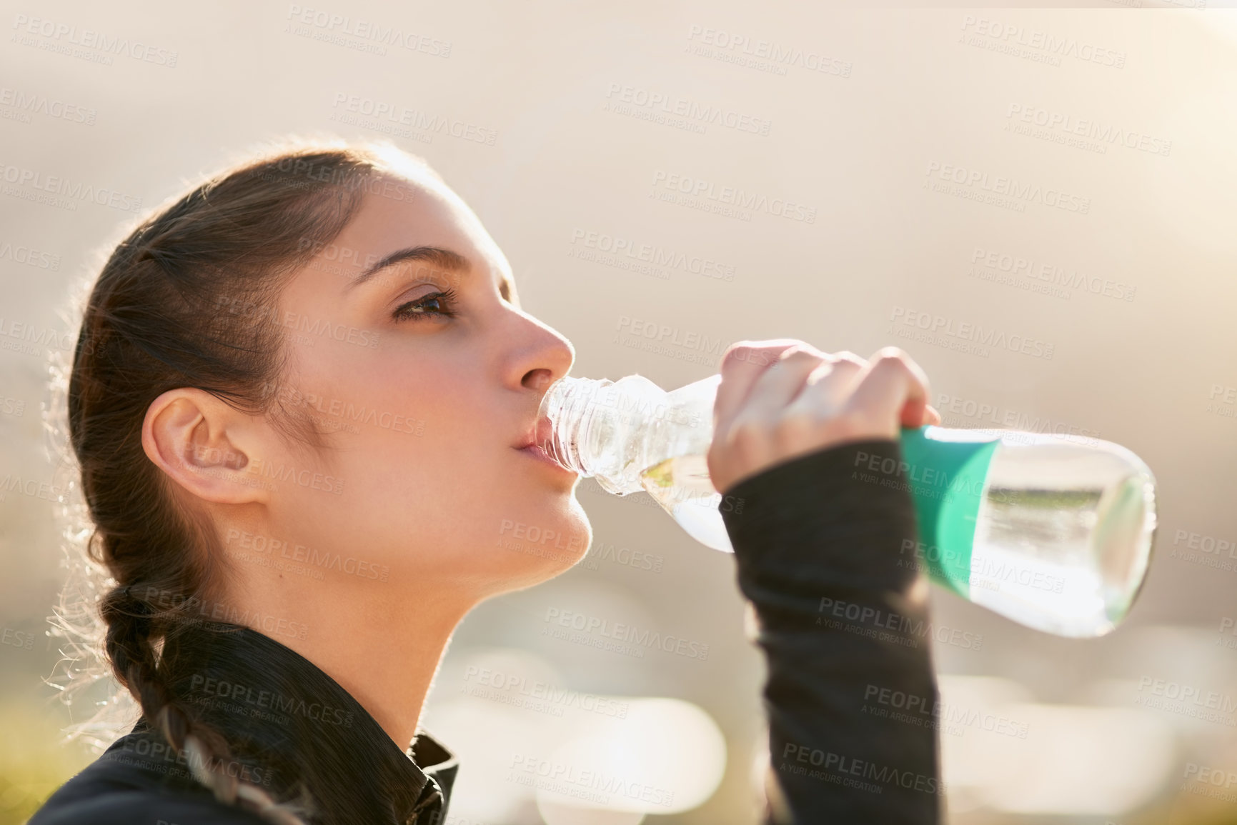 Buy stock photo Shot of an attractive young woman drinking water during her workout