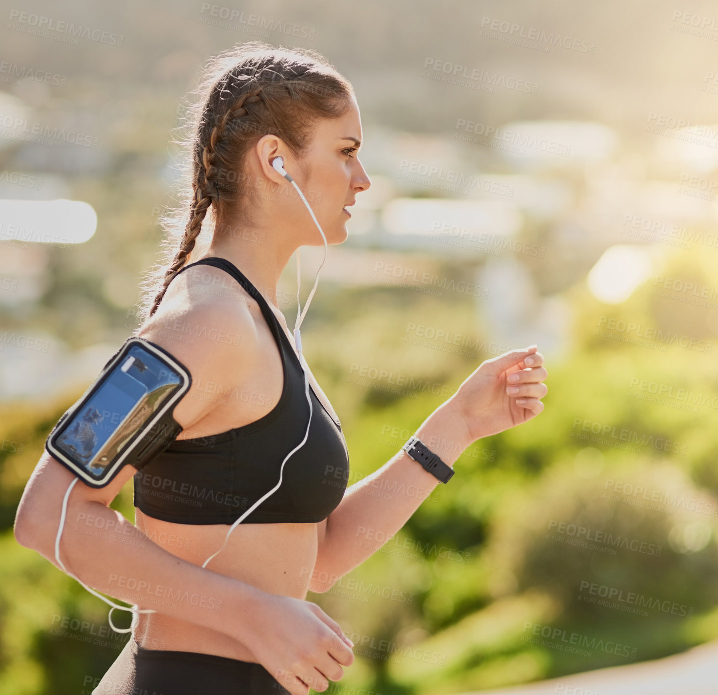 Buy stock photo Shot of an attractive young woman listening to music while out for her morning run