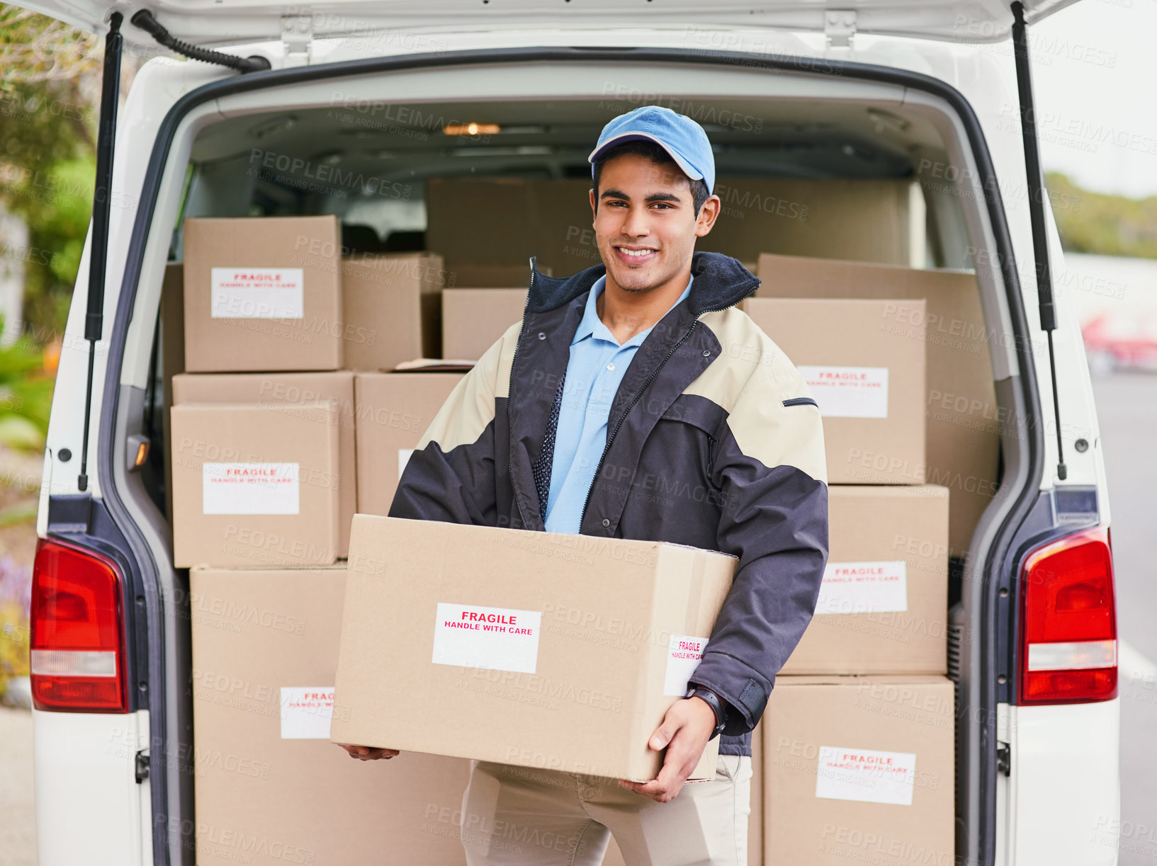 Buy stock photo Portrait of a delivery man unloading boxes from his van