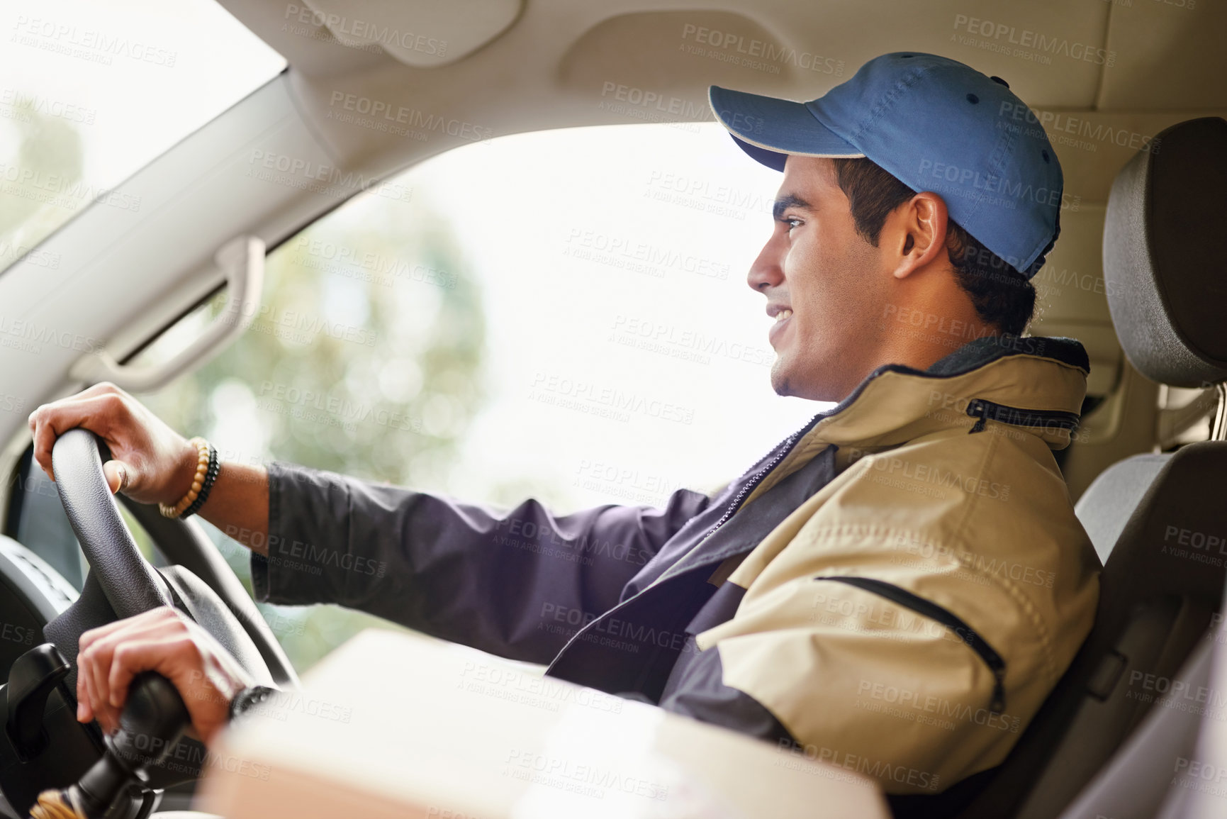 Buy stock photo Cropped shot of a delivery man driving in his van