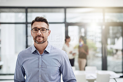Buy stock photo Defocused shot of a businessman posing with his colleagues in the background