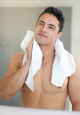 Buy stock photo Shot of a handsome young man drying off with a towel in the bathroom