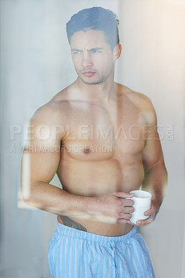 Buy stock photo Shot of a handsome young man having coffee in the morning at home