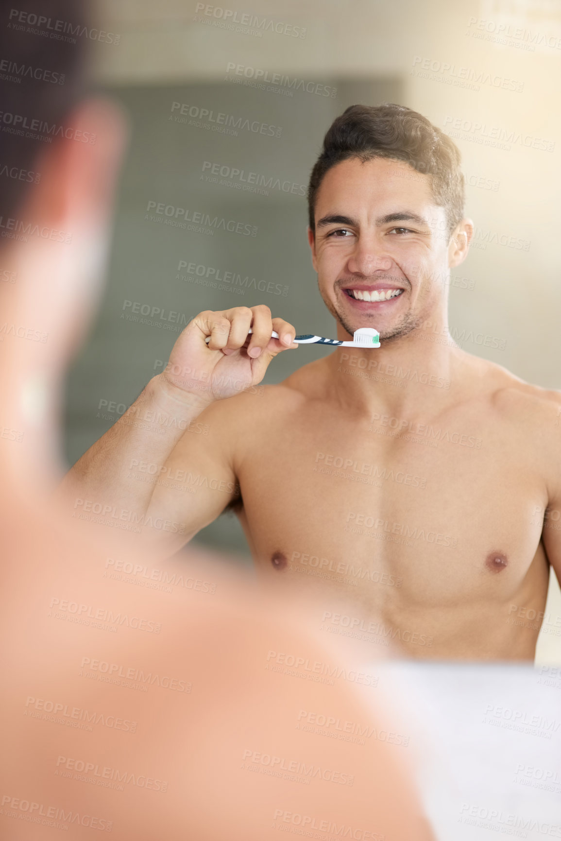 Buy stock photo Shot of a handsome young man brushing his teeth at home