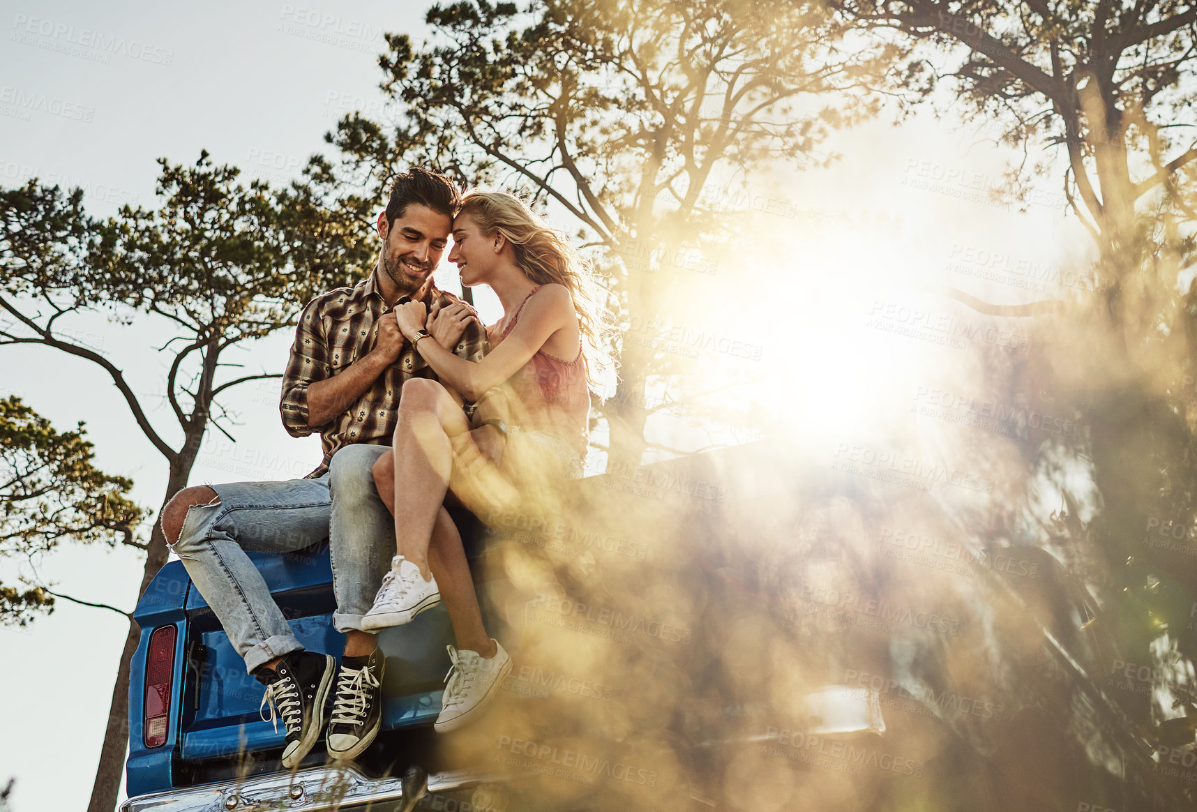 Buy stock photo Shot of an affectionate couple pulling over to admire the scenery while on a road trip