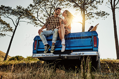 Buy stock photo Shot of an affectionate couple pulling over to admire the scenery while on a road trip