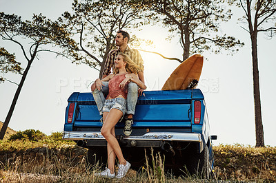 Buy stock photo Shot of an affectionate couple pulling over to admire the scenery while on a road trip