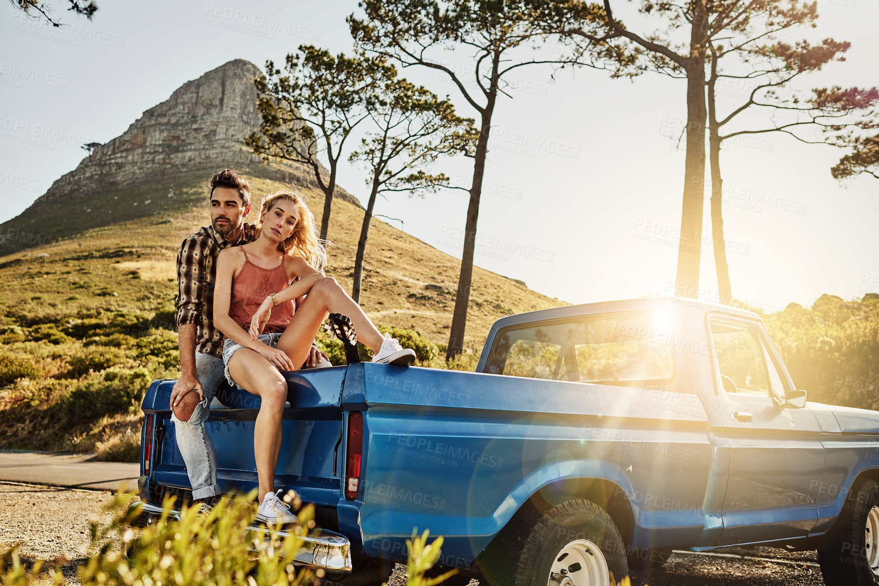 Buy stock photo Shot of an affectionate couple pulling over to admire the scenery while on a road trip