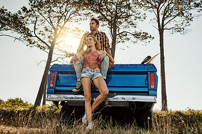 Buy stock photo Shot of an affectionate couple pulling over to admire the scenery while on a road trip