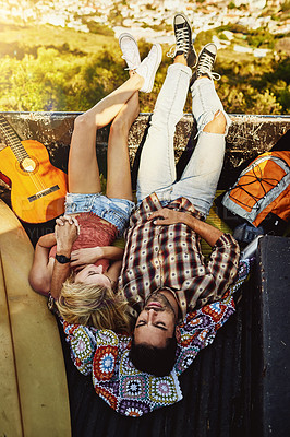 Buy stock photo Shot of a young couple lying at the back of a pickup truck to relax after a long drive