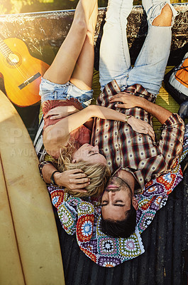 Buy stock photo Shot of a young couple lying at the back of a pickup truck to relax after a long drive