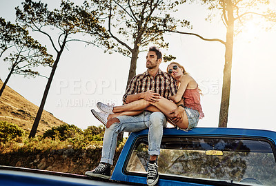 Buy stock photo Shot of an affectionate couple pulling over to admire the scenery while on a road trip