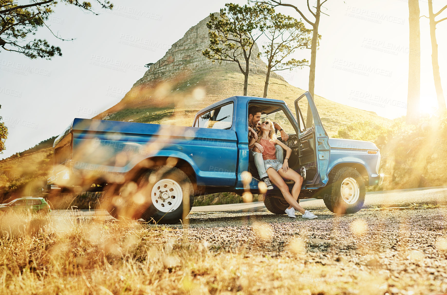 Buy stock photo Shot of a young couple out on a road trip with their truck