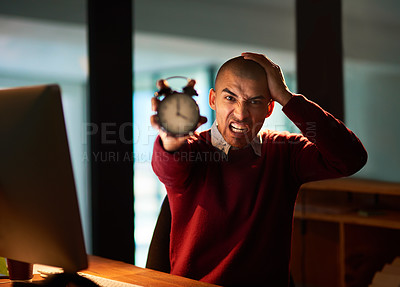 Buy stock photo Portrait of a young man freaking out about the time while working late in his office