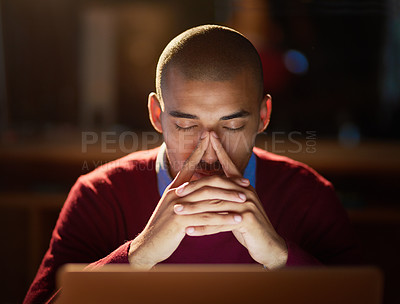 Buy stock photo Sho of a young man looking stressed out while working late in his office
