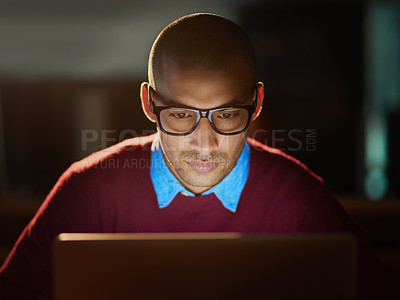 Buy stock photo Shot of a handsome young man working late in his office