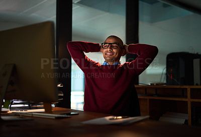 Buy stock photo Sho of a handsome young man looking relaxed while working late in his office