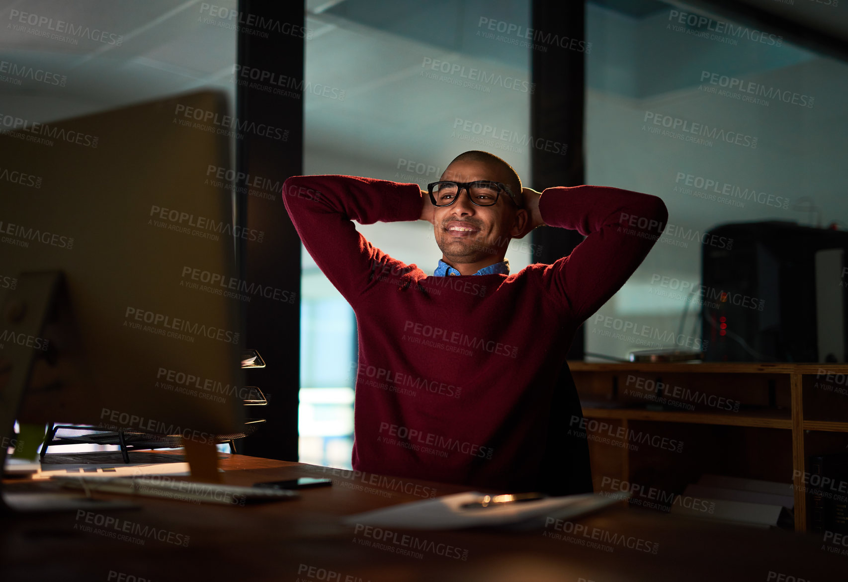 Buy stock photo Man, computer and smile in office at night for digital design, happiness or relax at desk. Male person, workplace or monitor with hands for job, website development or creative with satisfaction