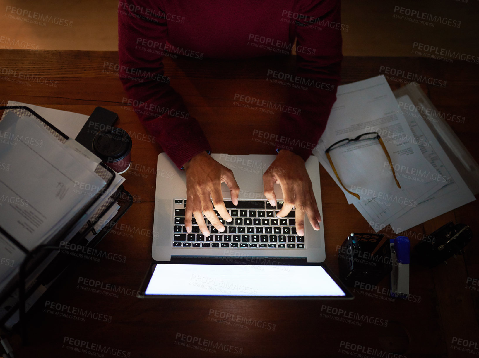Buy stock photo High angle shot of an unrecognizable man working late in the office