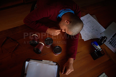 Buy stock photo High angle shot of a young man asleep at his desk while working late in the office