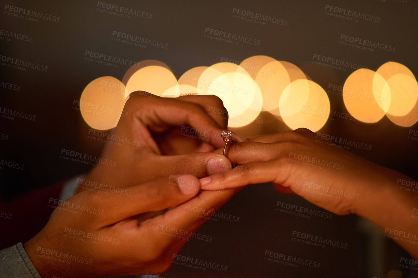 Buy stock photo Closeup shot of a man putting an engagement ring onto his fiancee’s finger