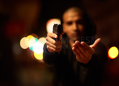 Buy stock photo Shot of a gun-wielding thief aiming his weapon