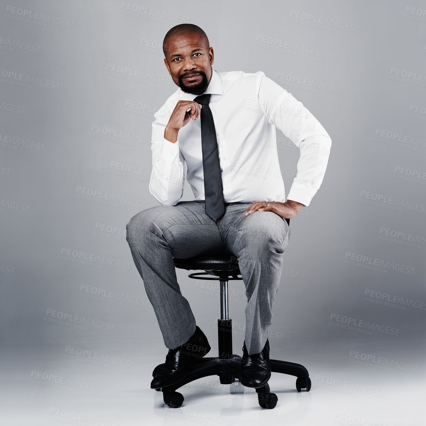 Buy stock photo Portrait, professional and black man with office chair of management consultant in studio. Corporate, about us and sitting executive with leader and pride from business success with grey background