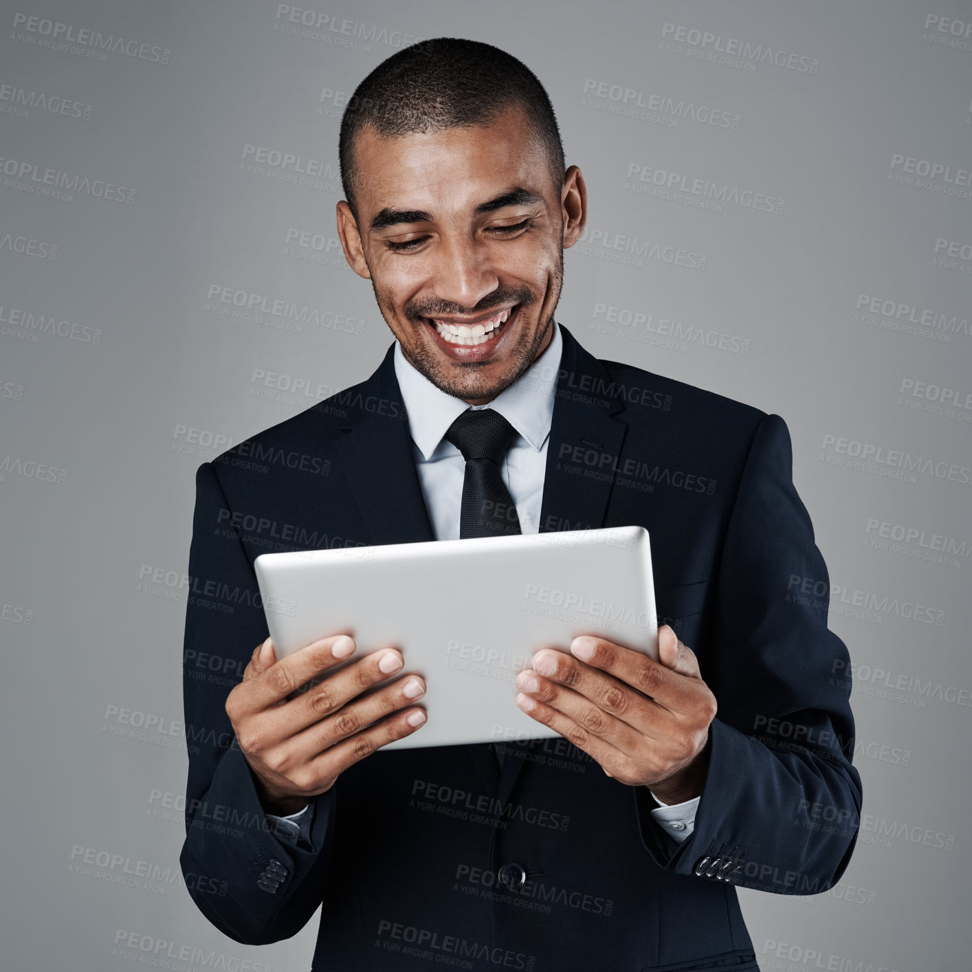 Buy stock photo Studio shot of a corporate businessman using a digital tablet against a grey background