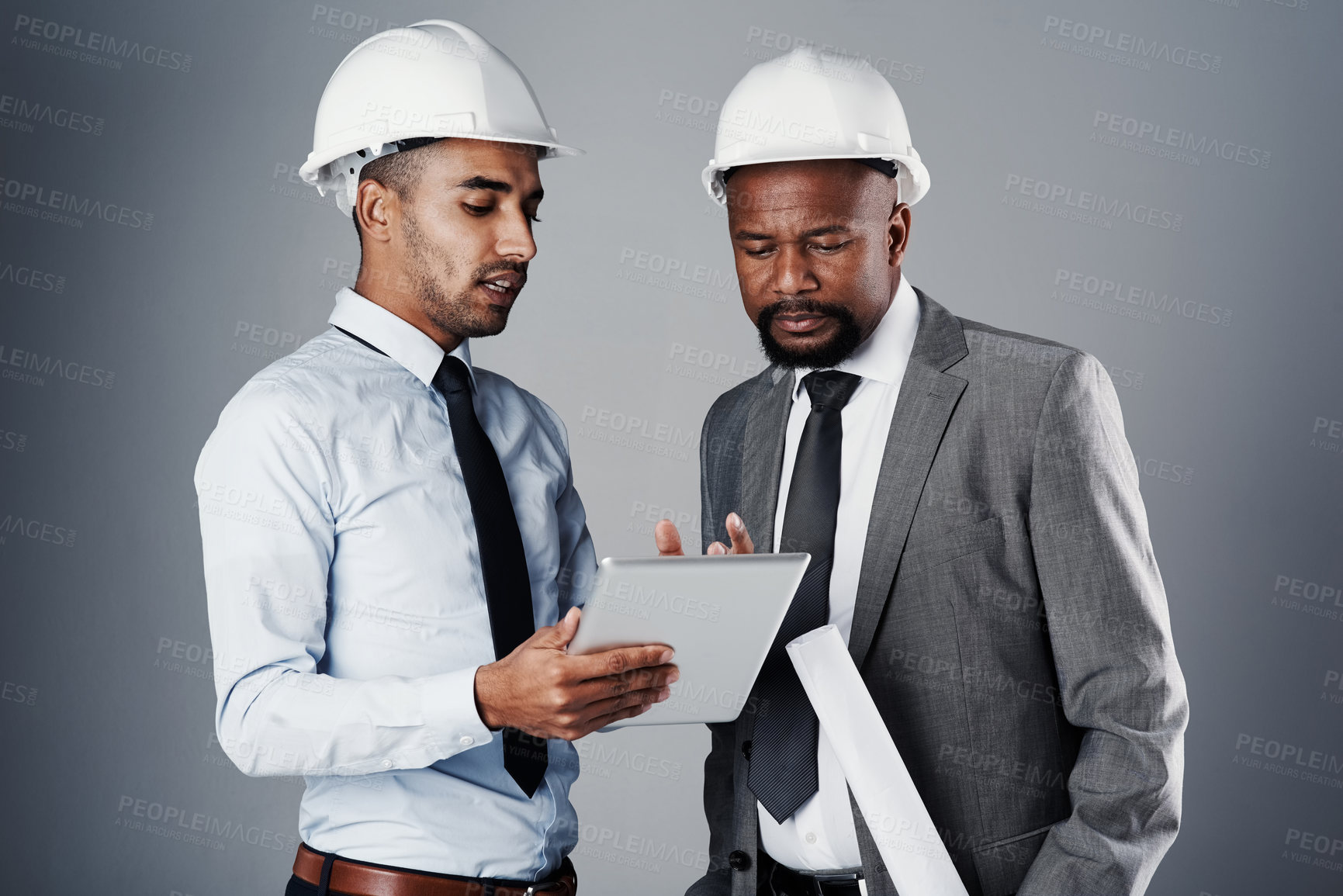 Buy stock photo People, architect and discussion with tablet in studio for construction, teamwork and renovation support. Men, talking and information, blueprint and collaboration with maintenance on gray background