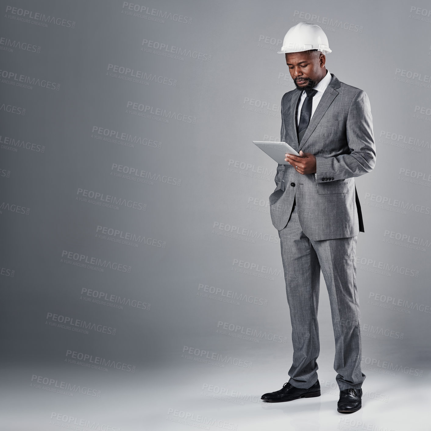 Buy stock photo Engineer, man and tablet in studio with suit, helmet and reading with mockup space by white background. African person, architect and touchscreen with application, review and floor plan for project