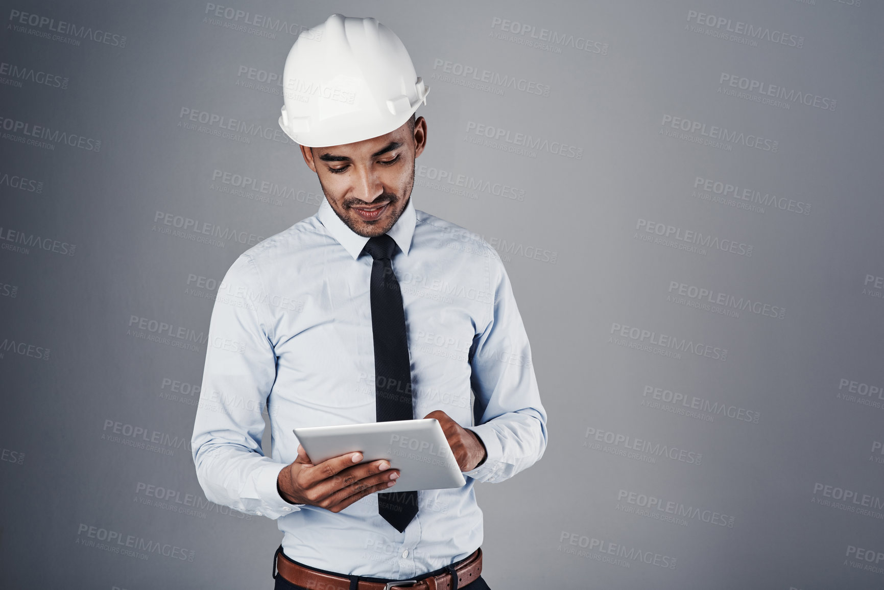 Buy stock photo Engineer, tablet and construction worker with digital research and online blueprint in studio. Contractor, planning and helmet of Indian male professional with web scroll, tech and grey background