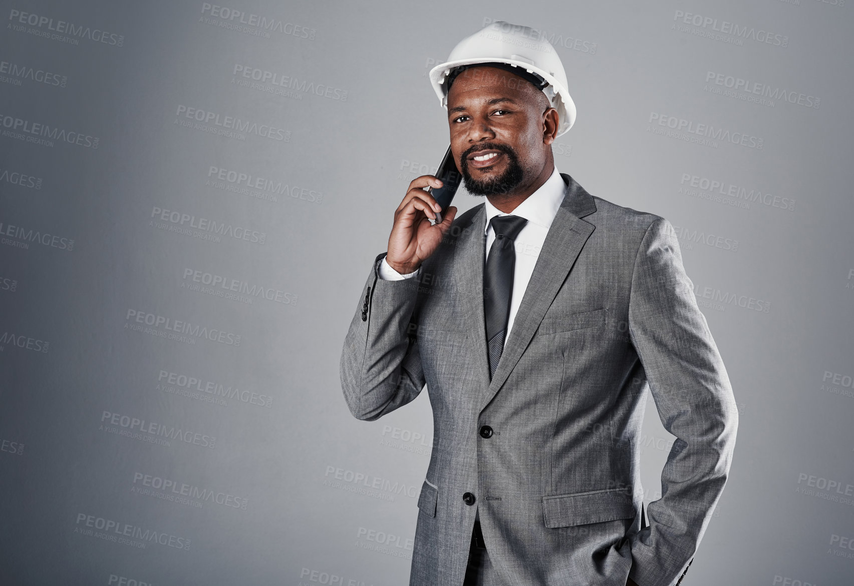 Buy stock photo Phone call, architecture and portrait of man in studio for construction, engineering and building project. Helmet, gray background and person on smartphone for talking, conversation and communication