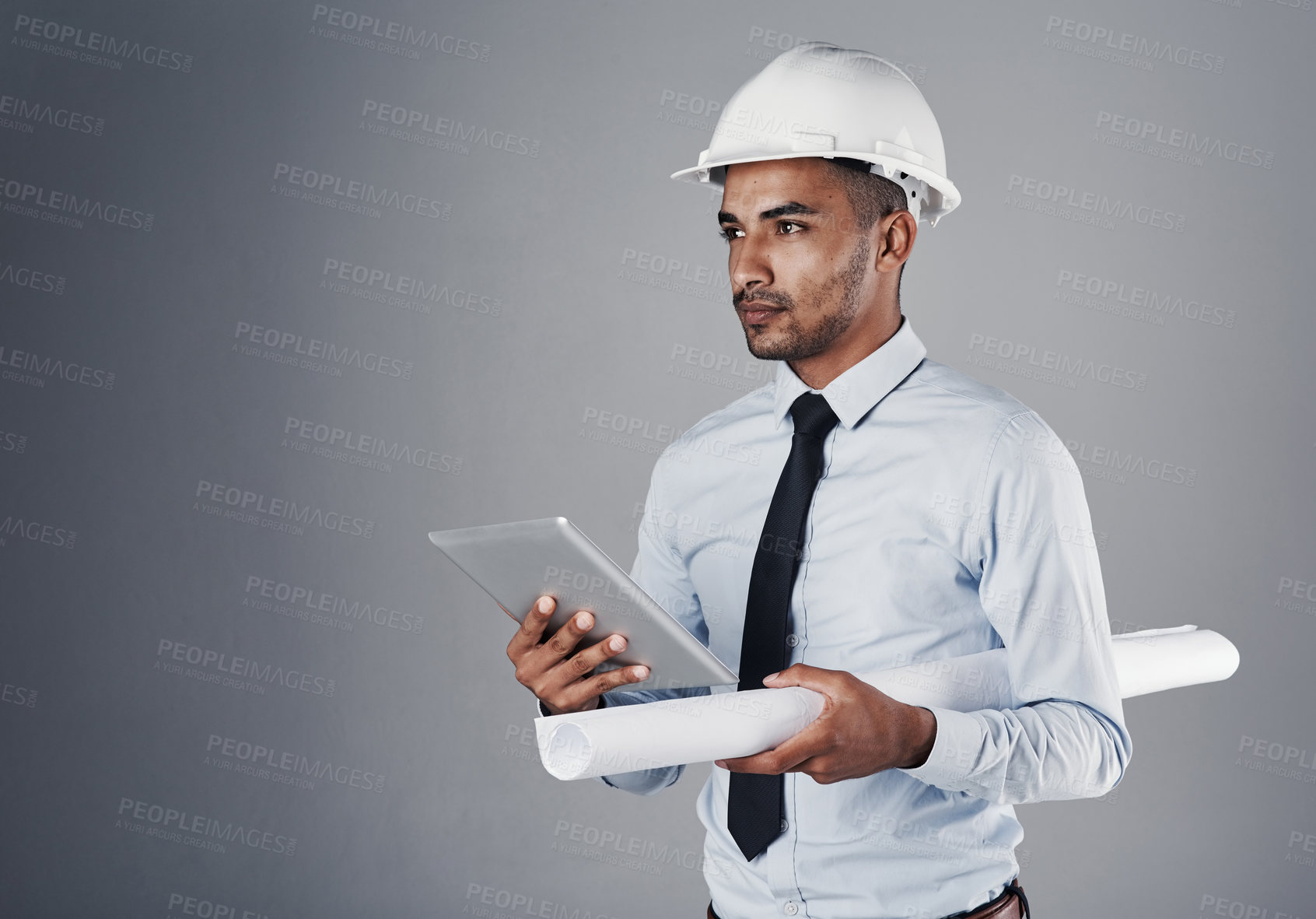 Buy stock photo Construction, blueprint and man on tablet in studio with online design, floorplan and building project. Architecture, gray background and engineer on digital tech for website, thinking and planning