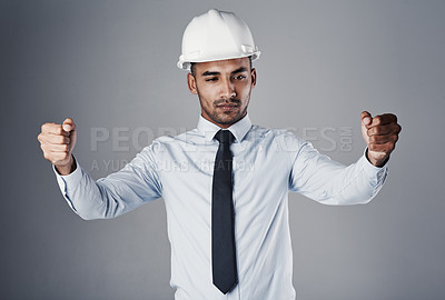 Buy stock photo Pretending, blueprint and Indian man with invisible document, plan of engineer with protection gear in studio. Helmet, manager and civil engineering with contractor and thinking with grey background