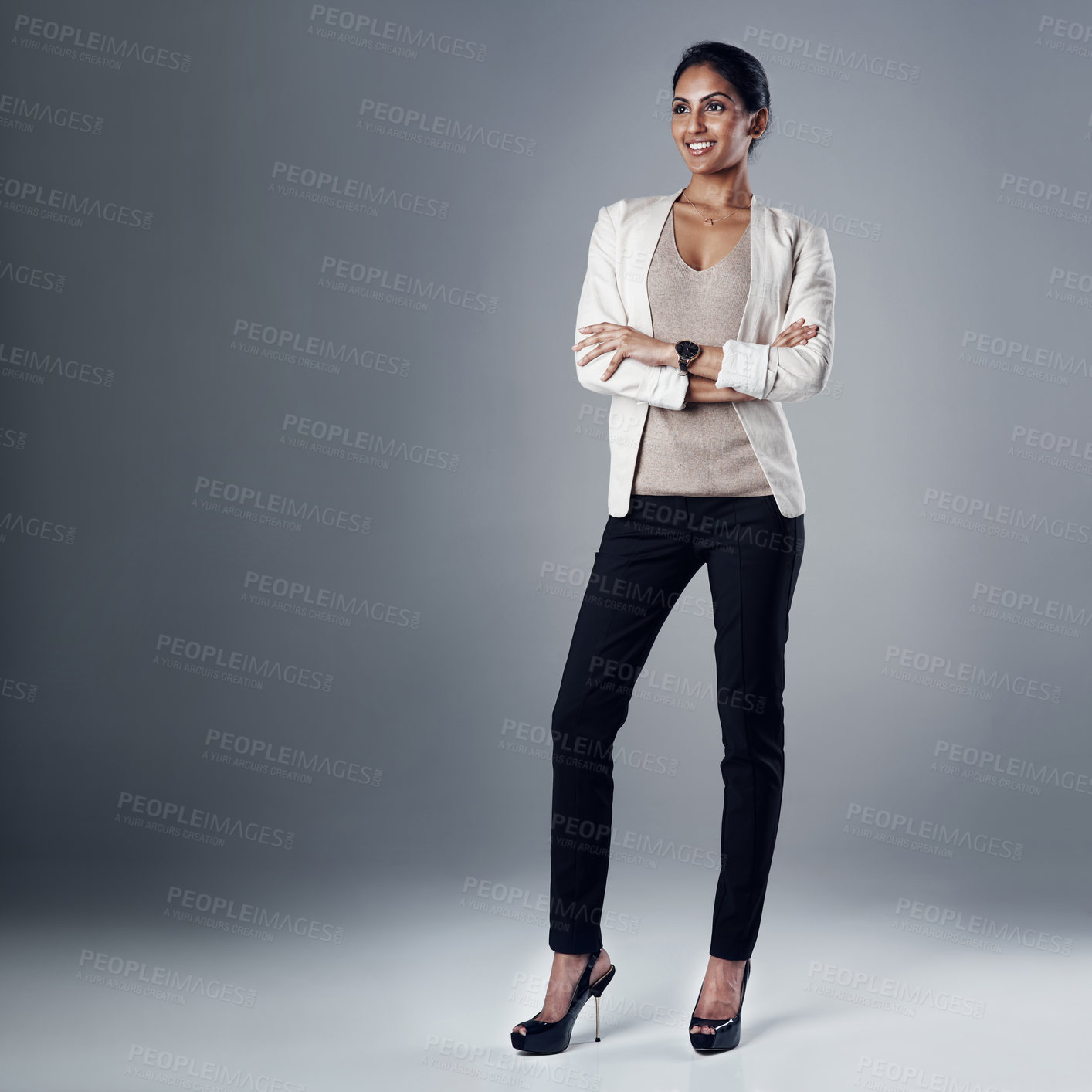 Buy stock photo Studio shot of a young businesswoman posing against a gray background