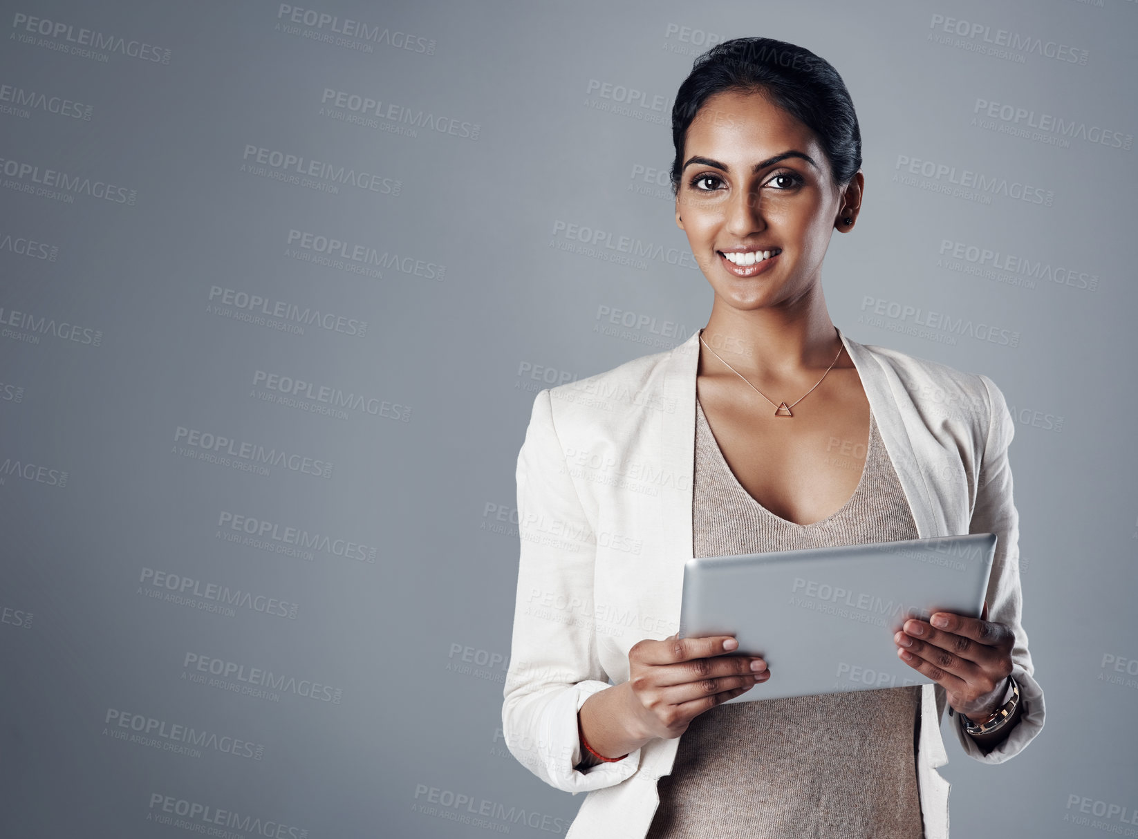 Buy stock photo Employee, woman and happy with tablet in studio for research as social media manager on gray background. Indian person, portrait and mockup space on internet for communication and online reviews